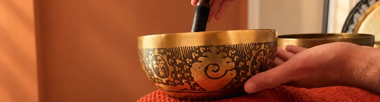 Bol tibétain gravé posé sur le corps pendant un massage sonore aux bols tibétains à Bonsecours